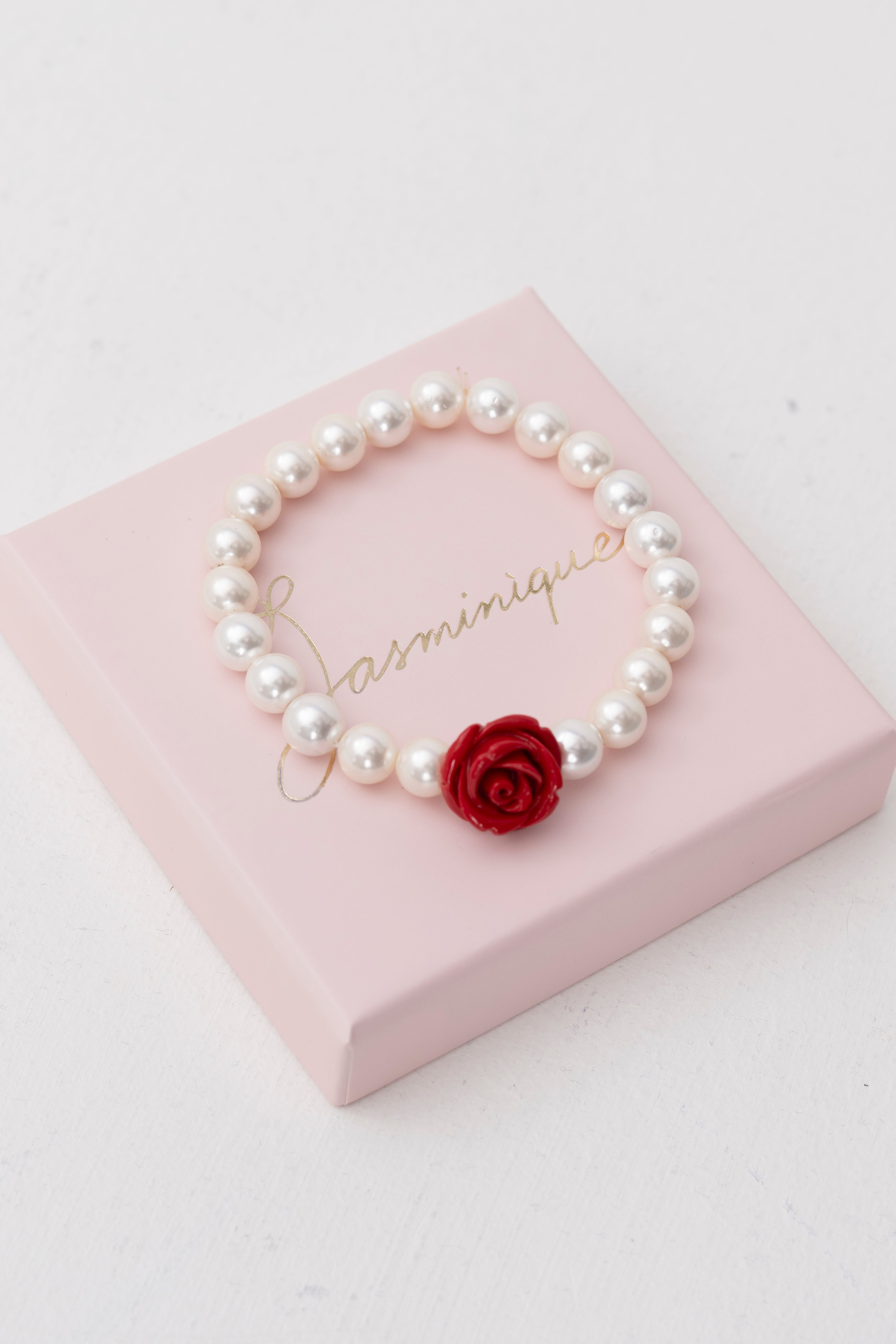 Bracciale di perle con rosa rossa intagliata